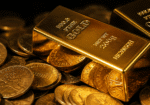 Gold bars resting on stacked coins, symbolizing the Fed impact on gold as investors react to weaker jobs data and shifting Federal Reserve expectations.
